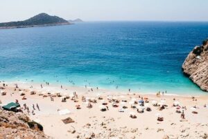 Spiaggia con ombrelloni in una baia dal mare turchese, vista dall'alto